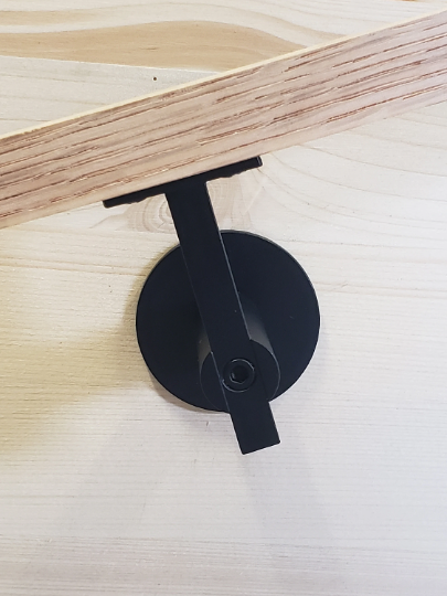 Modern handrail bracket. Flat black color. attached to a custom wooden railing.